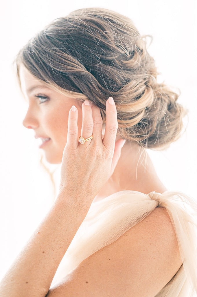 Photo edited by Refined Preset KT Merry of a bride wiping her hair away, focus on the ring and with her face delicately blurred.