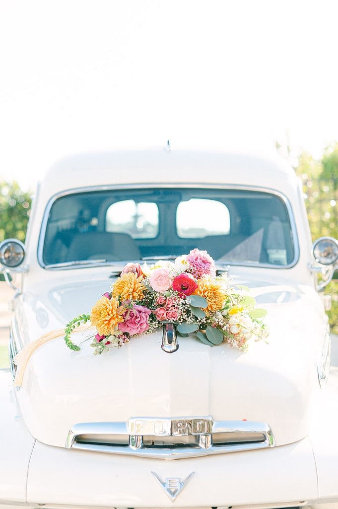 San Diego Wedding Photographer capturing a polished white truck called the TapTruck that has a beautiful brightly covered bouquet on top.